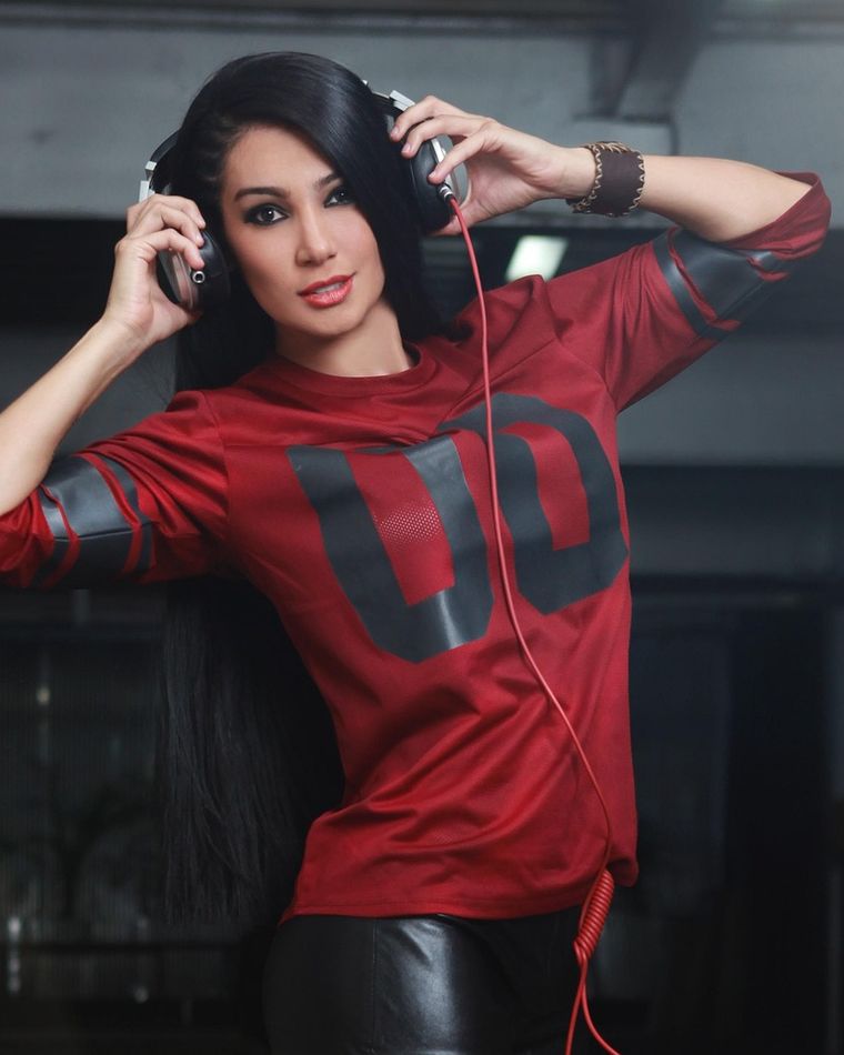 Retrato de LARA VOSS, DJ, com fones de ouvido.